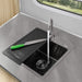 Elihome custom black RV sink cover placed over half of the sink, allowing faucet use while providing a cutting surface. Features a knife resting on the board and the engraved RV logo.