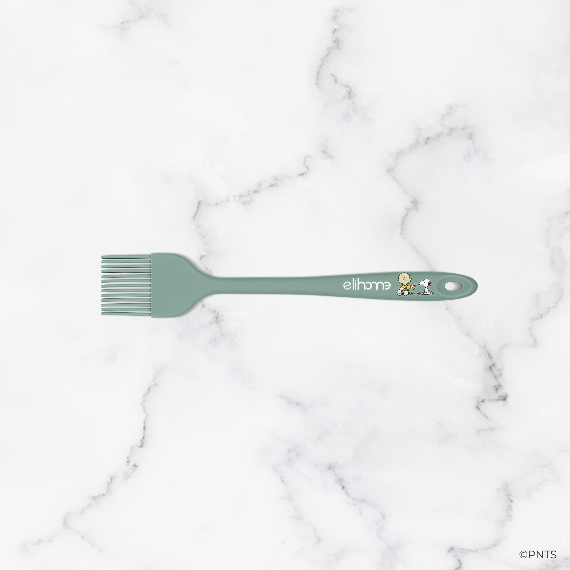 Green spatula with 'elihome' branding on a marble background
