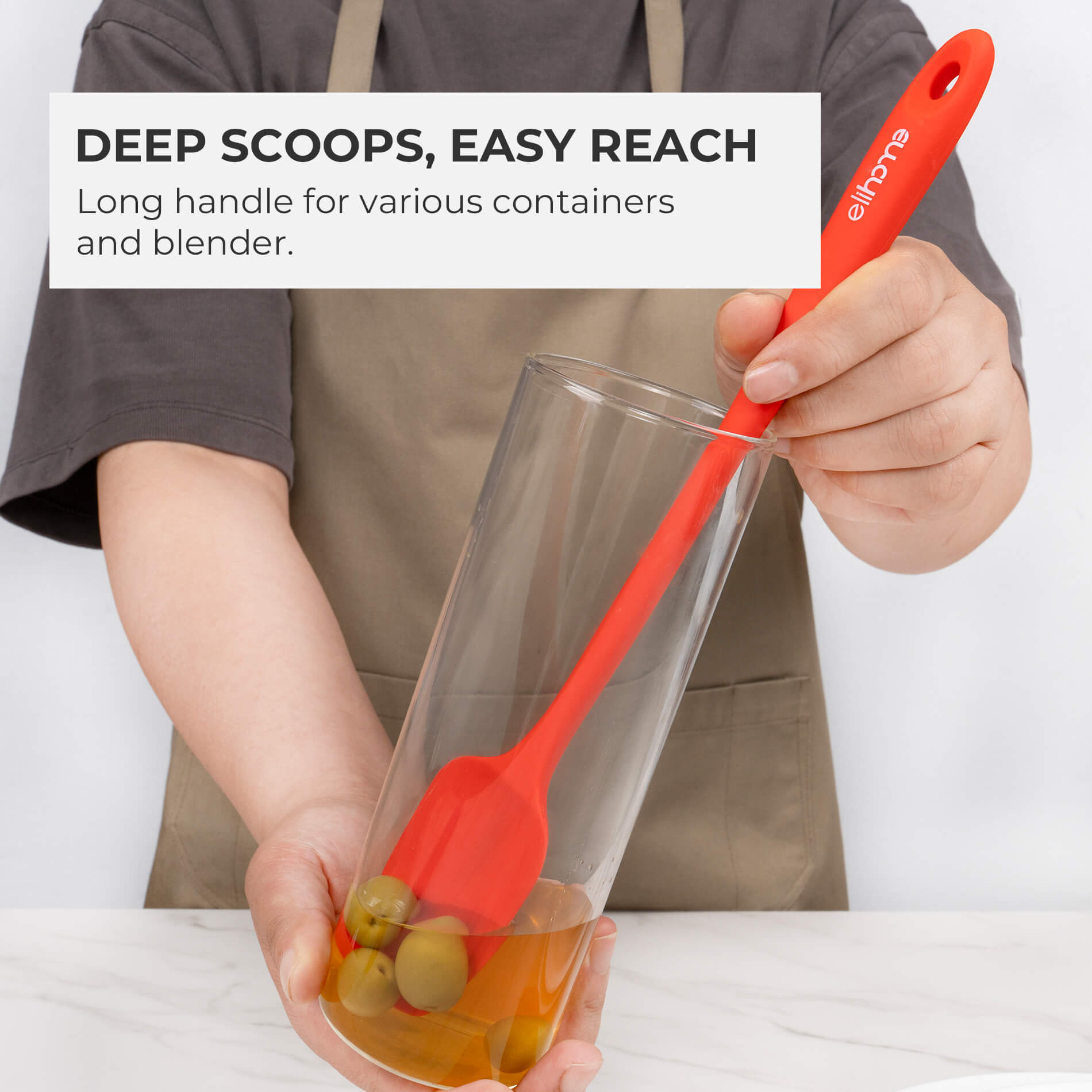 Elihome skinny silicone spatula used as a jar scraper, demonstrating how its 11-inch long handle reaches into a tall glass container to scoop olives. Text reads: 