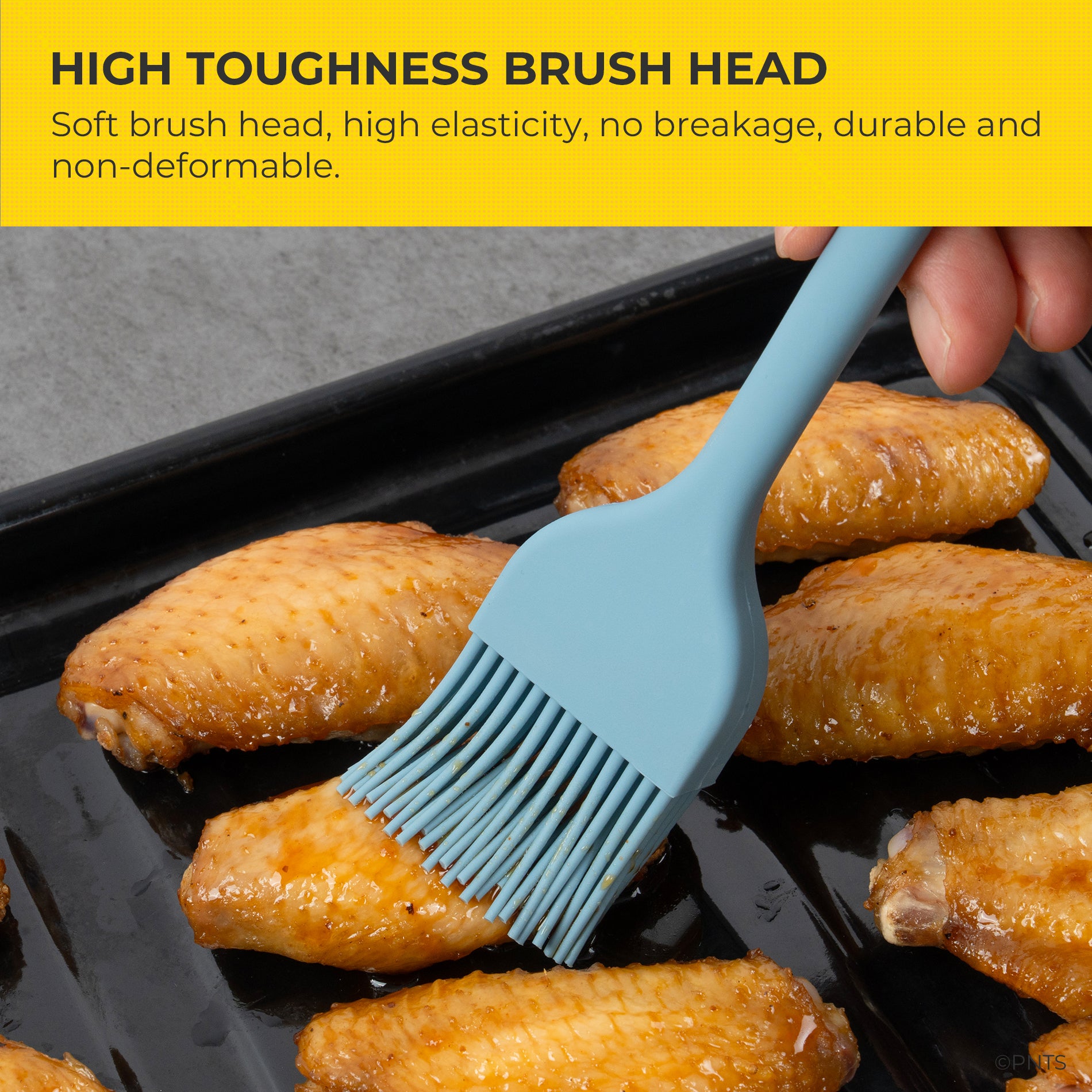 Blue silicone brush being used to baste chicken wings on a grill with text about brush head durability.