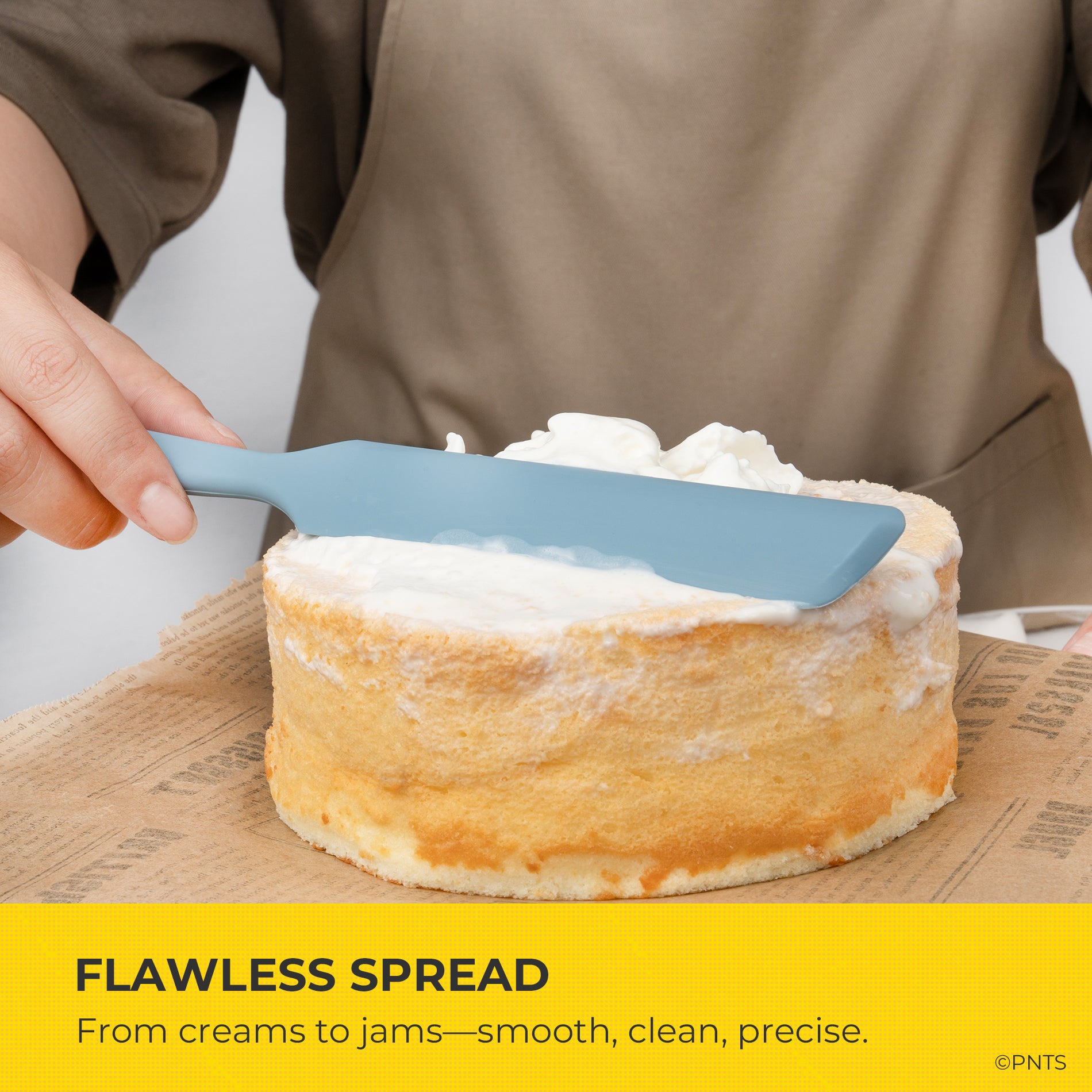 Person spreading cream on a cake with a blue spatula, text 'Flawless Spread' at the bottom.