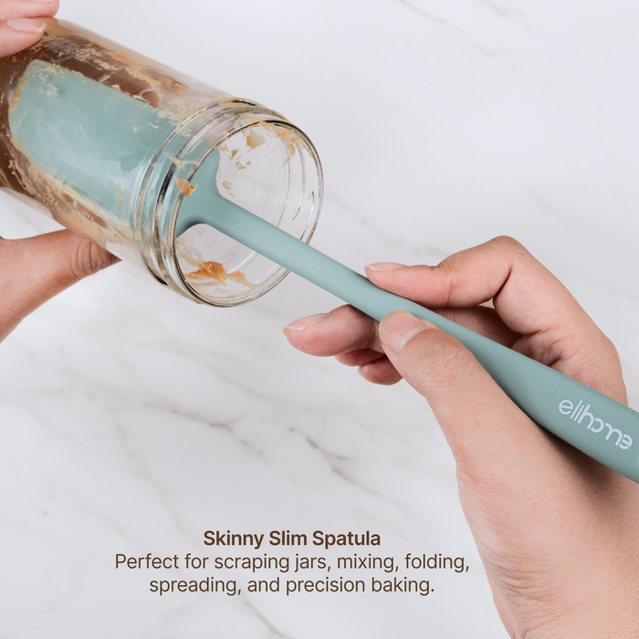 Elihome Skinny Slim Silicone Spatula from the silicone kitchen tool set in use, scraping the inside of a glass jar