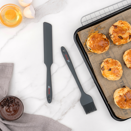 Elihome Premium Silicone Spreader and Silicone Basting Brush in Gray on a marble counter beside a baking tray of freshly baked scones, egg yolk and melted chocolate