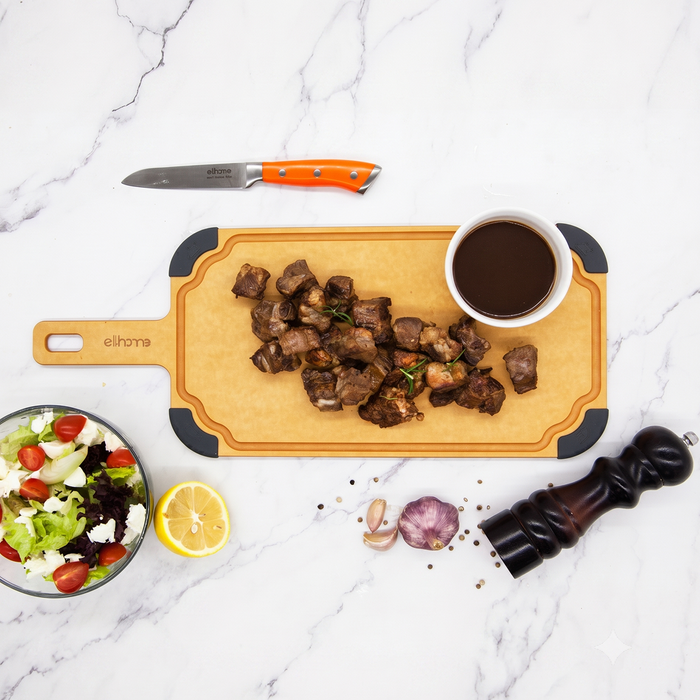 Sliced meat served with dipping sauce on the Elihome Paddle Series Large cutting and serving board